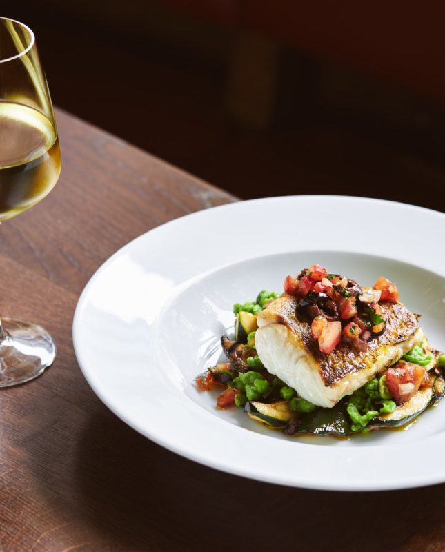 White wine and cod dish in restaurant