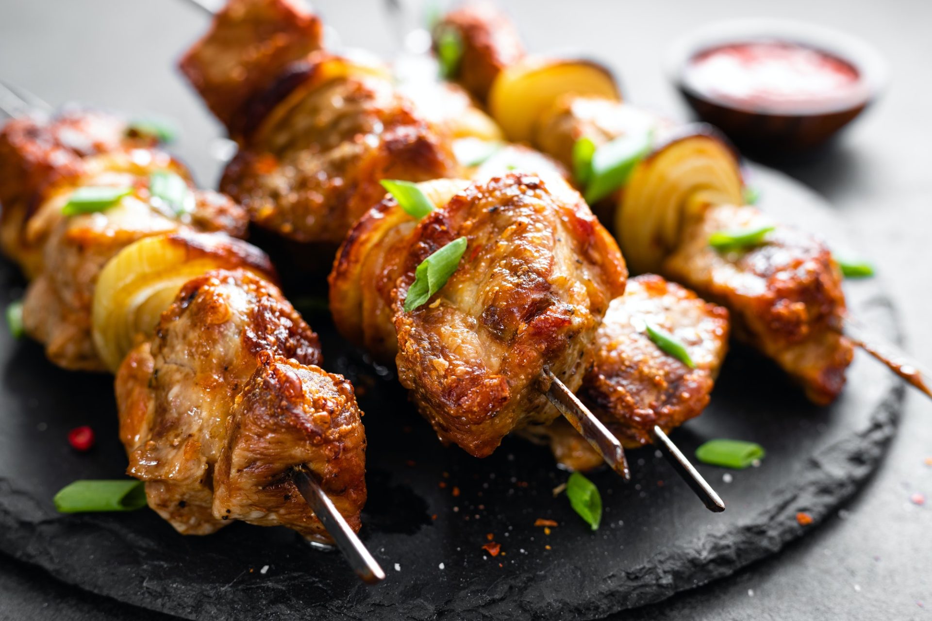 Grilled meat skewers, shish kebab on black background