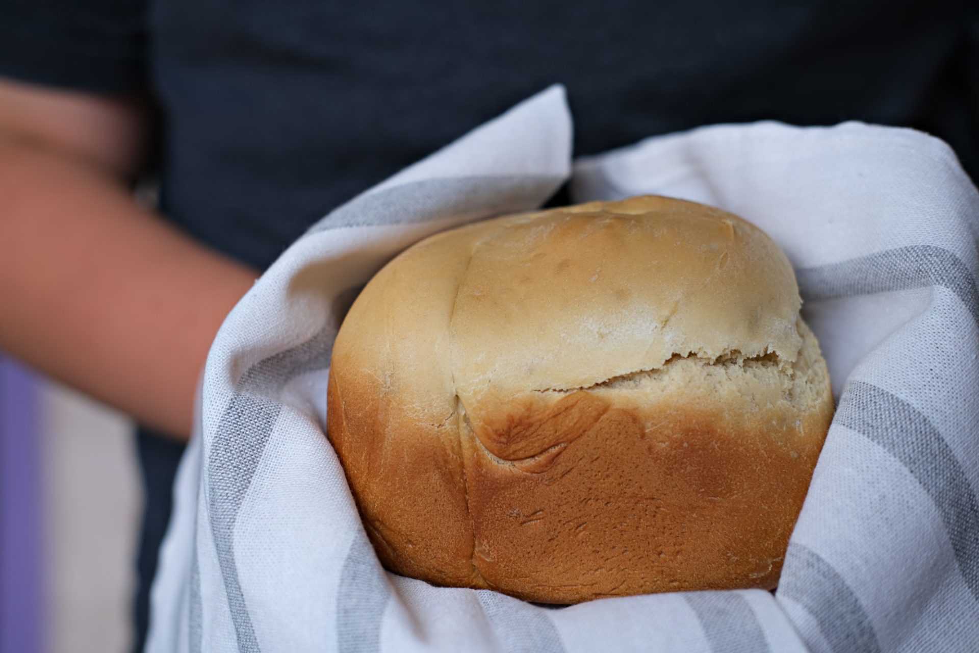 teenager boy holding fresh baked bread.