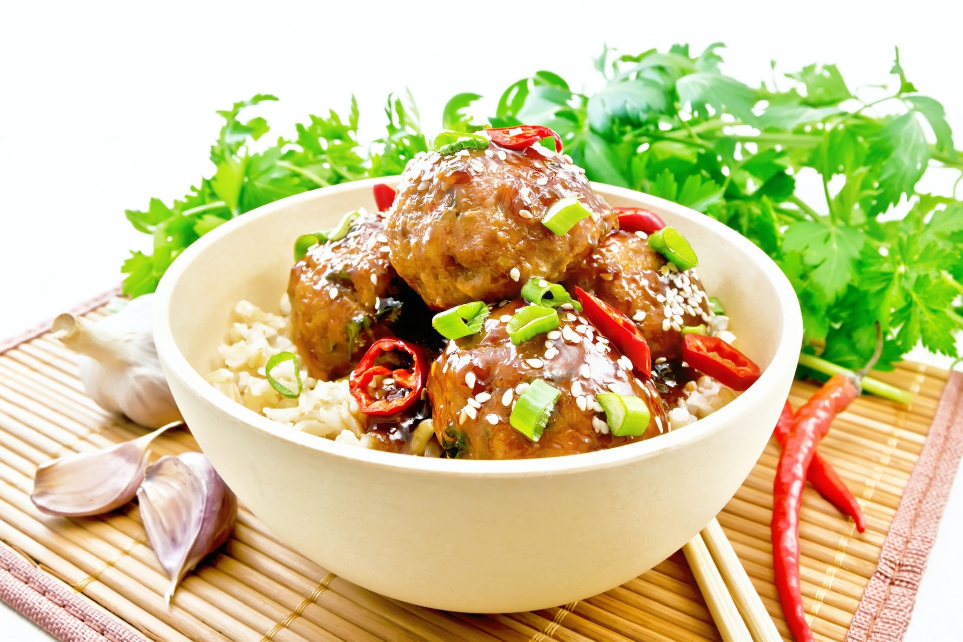 Meatballs in sweet and sour sauce with rice on wooden board